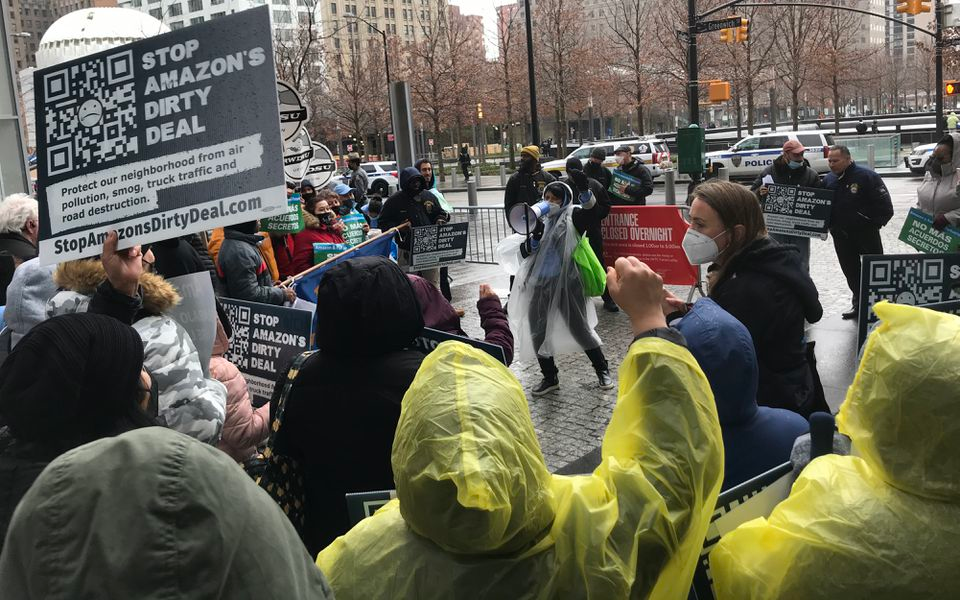 An organizer leads a crowd of demonstrators in a chant against a planned Amazon air cargo hub at Newark airport Thursday at Port Authority headquarters at 4 World Trade center in New York.