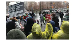 An organizer leads a crowd of demonstrators in a chant against a planned Amazon air cargo hub at Newark airport Thursday at Port Authority headquarters at 4 World Trade center in New York.