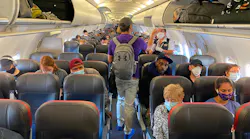 Passengers, almost all wearing facemasks, board an American Airlines flight to Charlotte, North Carolina, on May 3, 2020, in New York City.