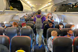 Passengers, almost all wearing facemasks, board an American Airlines flight to Charlotte, North Carolina, on May 3, 2020, in New York City.