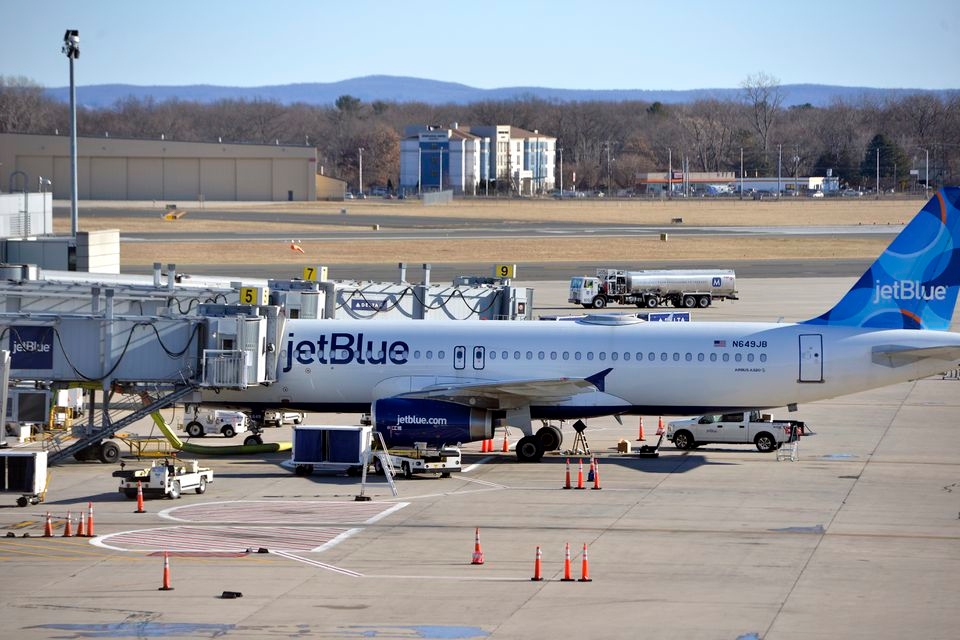 A JetBlue jet is parked at the gate at Terminal A at Bradley International Aiport, December 23, 2021.