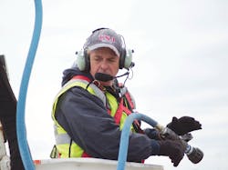 Bucket personnel wear wireless headsets to communicate hands-free with the driver in deicing vehicles.
