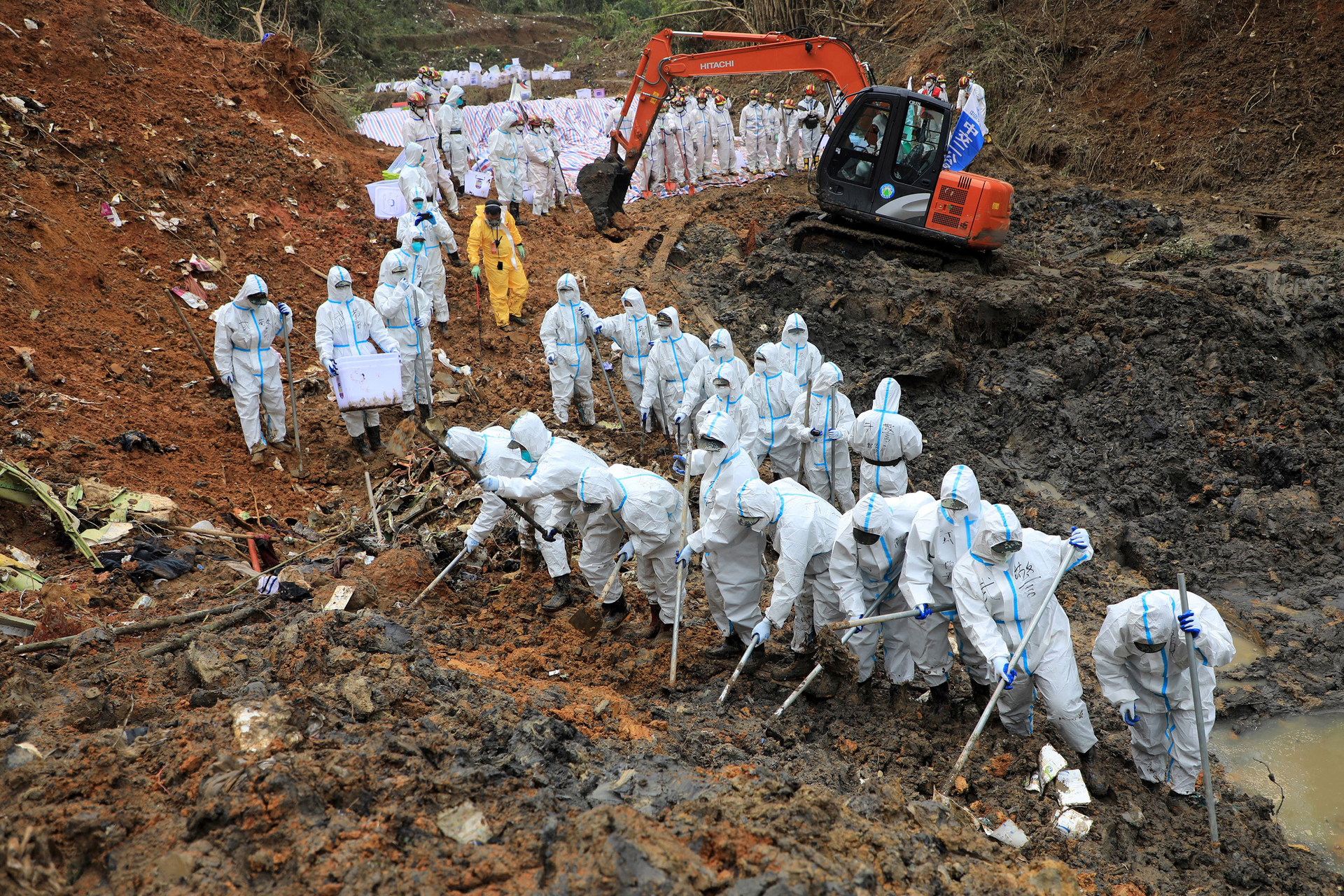 On March 26, 2022 paramilitary police officers comb through the site of where China Eastern flight MU5375 crashed, in Wuzhou, China. The Boeing 737-800 was flying between the cities of Kunming and Guangzhou on March 21 when it nosedived into a mountainside, disintegrating on impact and killing all 132 people on board.