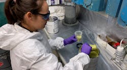 A materials engineer from the Naval Air Warfare Center Aircraft Division prepares to spray a qualified paint product in a corrosion lab at Naval Air Station Patuxent River.