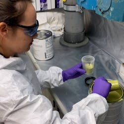 A materials engineer from the Naval Air Warfare Center Aircraft Division prepares to spray a qualified paint product in a corrosion lab at Naval Air Station Patuxent River.