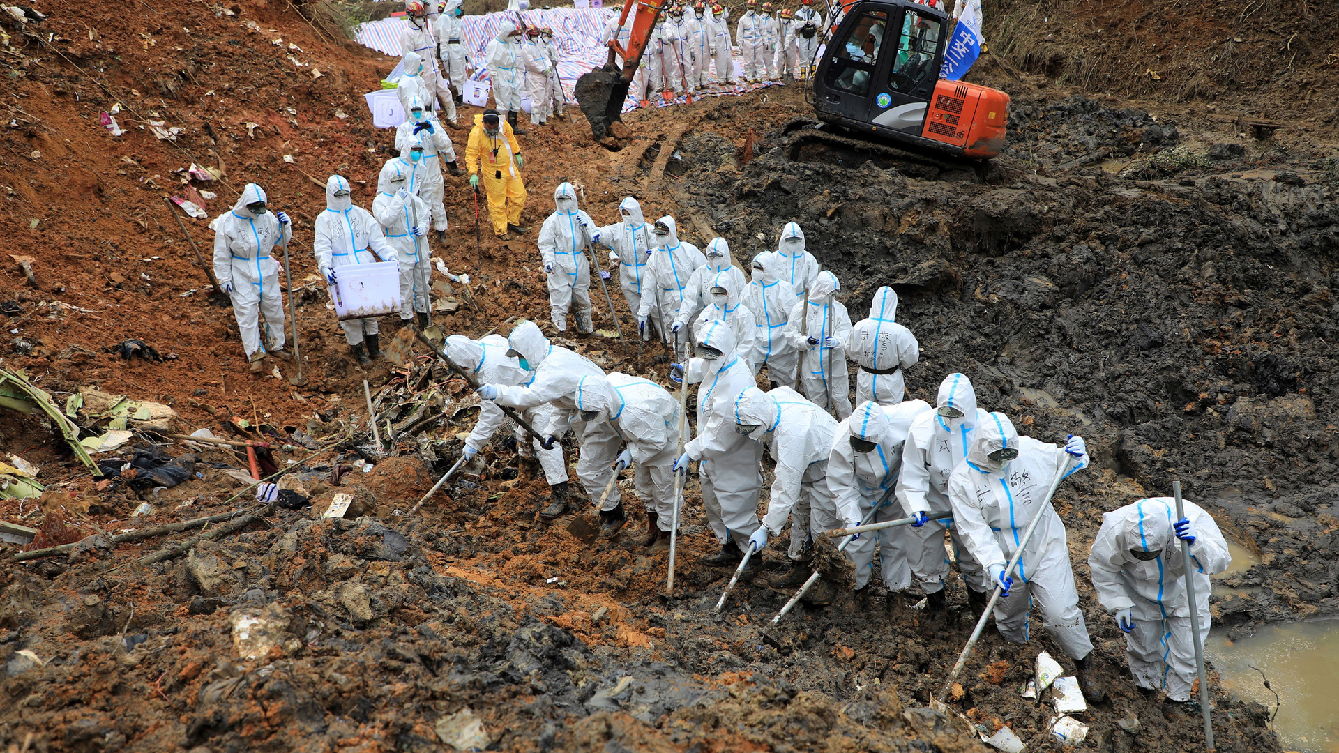 On March 26, 2022 paramilitary police officers comb through the site of where China Eastern flight MU5375 crashed, in Wuzhou, China. The Boeing 737-800 was flying between the cities of Kunming and Guangzhou on March 21 when it nosedived into a mountainside, disintegrating on impact and killing all 132 people on board.