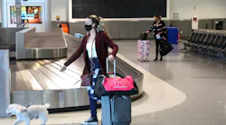 Travelers are photographed at the baggage claim area in Terminal 2 of the Oakland International Airport on Tuesday, Dec. 22, 2020, in Oakland, Calif.