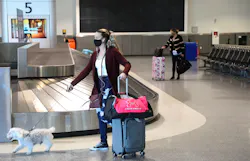 Travelers are photographed at the baggage claim area in Terminal 2 of the Oakland International Airport on Tuesday, Dec. 22, 2020, in Oakland, Calif.