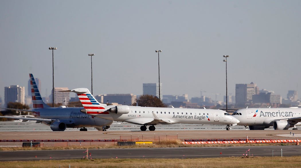 American Eagle and American Airlines planes make their way toward the runway before taking off at DFW International Airport in 2020.