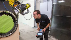 Landon Beachy, process engineer, tests a robot s ability to move closely over a part to be coated. Landon Beachy, process engineer, tests a robot s ability to move closely over a part to be coated.