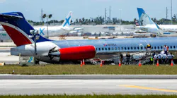 National Transportation Safety Board agents, Federal Aviation Administration agents and Miami-Dade Fire Rescue crews on Wednesday surround the RED Air plane that crash-landed on Tuesday at Miami International Airport.