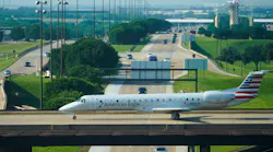 An American Eagle plane taxis on a bridge over International Parkway at DFW Airport on in May.
