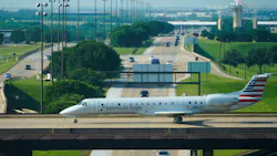 An American Eagle plane taxis on a bridge over International Parkway at DFW Airport on in May.