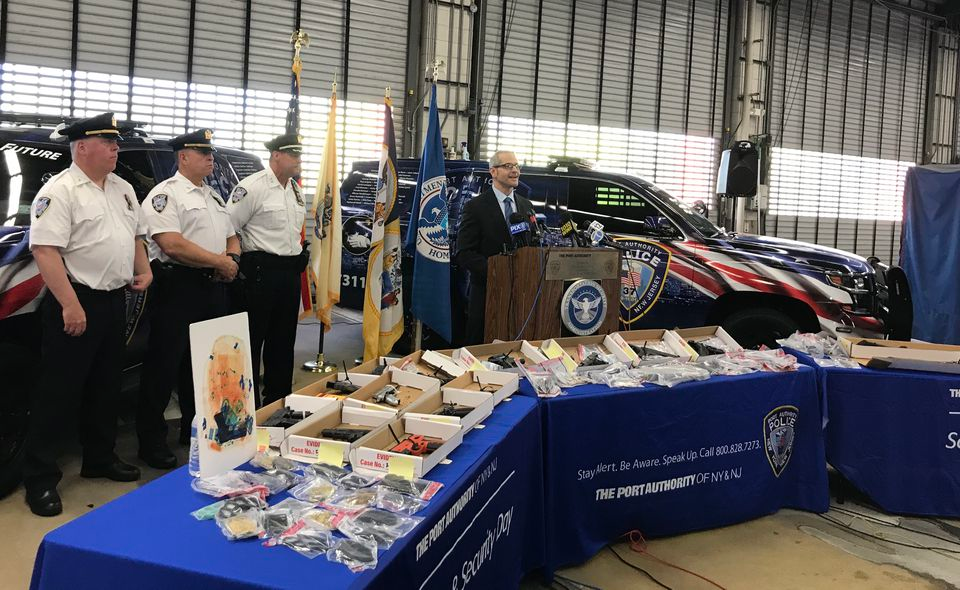 Transportation Security Administration New Jersey director Tom Carter talks about an increase in guns confiscated at Newark Airport at Port Authority Police headquarters at the airport. Confiscated weapons filed three tables in front of him.