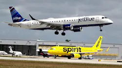 A JetBlue Airways plane passes a Spirit Airlines jet as it lands at Fort Lauderdale Hollywood International Airport. Frontier Airlines, which is seeking to acquire majority control of Spirit, announced late Thursday it had added a $250 million reverse breakup fee to its offer. The move was in response to a JetBlue counter-offer that includes a fee of $200 million.