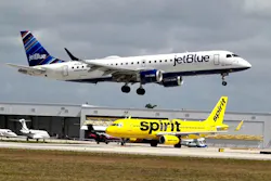 A JetBlue airliner lands past a Spirit Airlines jet on taxi way at Fort Lauderdale Hollywood International Airport on Monday, April 25, 2022.