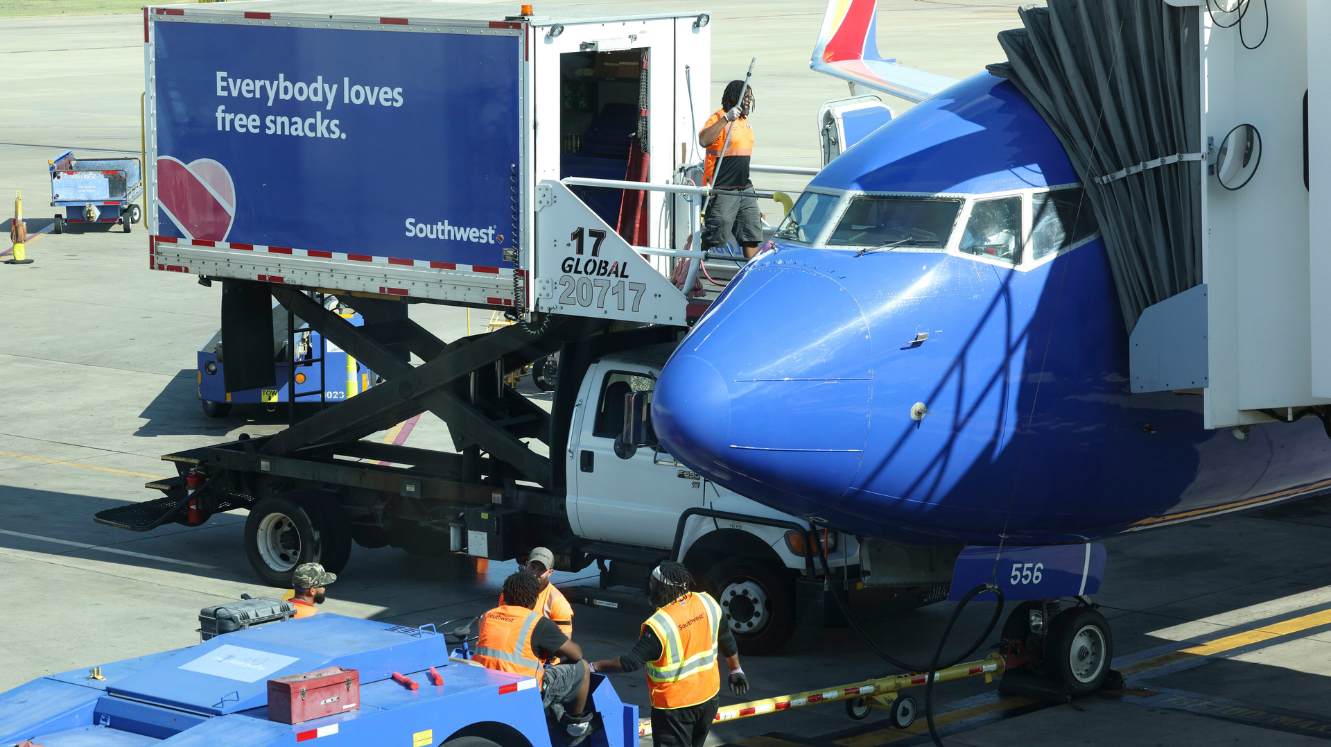 Airport workers wait on the tarmac as people board a plane to Washington, D.C., on July 1 at Dallas Love Field Airport.