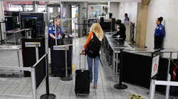 A passenger makes her way through a TSA security checkpoint at DFW International Airport on Wednesday, April 8, 2020.