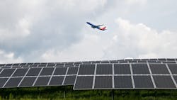 A Southwest plane takes off over 9,360 solar panels at Pittsburgh International Airport, part of a first-of-its-kind microgrid.