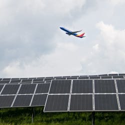 A Southwest plane takes off over 9,360 solar panels at Pittsburgh International Airport, part of a first-of-its-kind microgrid.