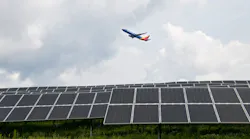 A Southwest plane takes off over 9,360 solar panels at Pittsburgh International Airport, part of a first-of-its-kind microgrid.