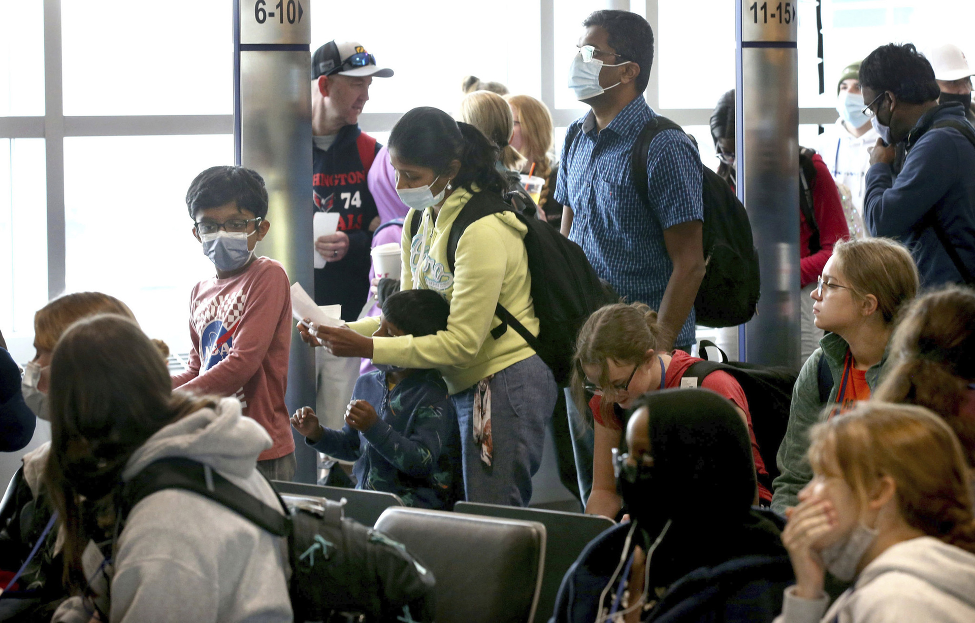 Air travelers wait in line to board their aircraft at Midway International Airport in Chicago, Tuesday April 19, 2022.