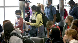 Air travelers wait in line to board their aircraft at Midway International Airport in Chicago, Tuesday April 19, 2022.