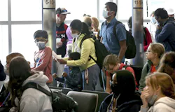 Air travelers wait in line to board their aircraft at Midway International Airport in Chicago, Tuesday April 19, 2022.