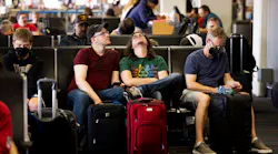 Tommy McCarver, center left, and husband Kyle Murell, center right, wait for their flight to Washington, D.C., after it was delayed about an hour at Dallas/Fort Worth International Airport on Friday, July 1, 2022.