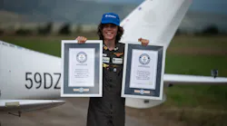 Mack Rutherford, 17, the youngest person to fly solo around the world, poses for photographers while displaying the Guiness World Record certificates, after landing at Sofia West airport near Radomir on Wednesday, Aug. 24, 2022.