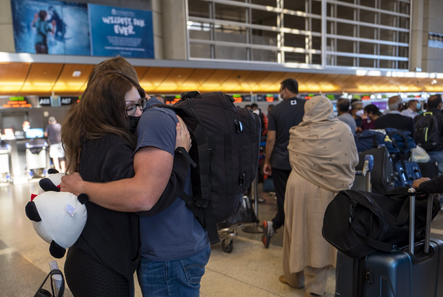 LOS ANGELES, CA - NOVEMBER 28: Paloma Camacho, 21, hugs at Anthony Long, 22, before her flight at Tom Bradley International Terminal on Sunday, Nov. 28, 2021 in Los Angeles, CA. Sunday after Thanksgiving is one of the busiest days of the year at LAX.