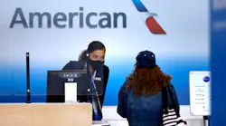 An American Airlines customer assistance representative checks-in a passenger in Terminal A at Dallas-Fort Worth International Airport on March 24, 2021.