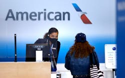 An American Airlines customer assistance representative checks-in a passenger in Terminal A at Dallas-Fort Worth International Airport on March 24, 2021. An American Airlines customer assistance representative checks-in a passenger in Terminal A at Dallas-Fort Worth International Airport on March 24, 2021.