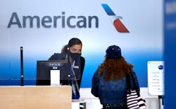 An American Airlines customer assistance representative checks-in a passenger in Terminal A at Dallas-Fort Worth International Airport on March 24, 2021.