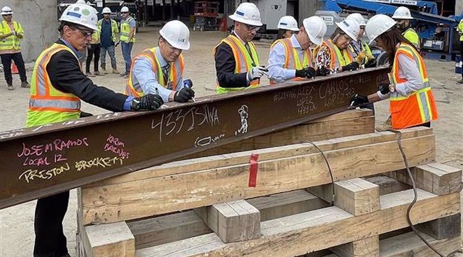 Signing the last structural station steel beam prior to it being hoisted into place.