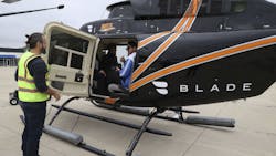 Passengers are loaded into a helicopter during a test flight to simulate an electric flying taxi at Vertiport Chicago on Sept. 13, 2022. Passengers are loaded into a helicopter during a test flight to simulate an electric flying taxi at Vertiport Chicago on Sept. 13, 2022.