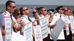 Southwest Airlines pilots drink water while picketing for better work conditions on June 21, 2022, outside Dallas Love Field.