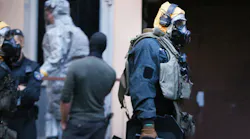 Picture taken on June 12, 2018, shows police officers of a special unit wearing protective clothes and respiratory masks during an operation in Cologne's Chorweiler district, western Germany, where police found toxic substances after storming a flat. - A Tunisian man arrested in Germany is suspected of trying to build a biological weapon using the deadly poison ricin, prosecutors said ...