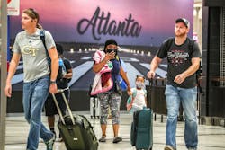 September 1, 2022 Hartsfield-Jackson International Airport: Kenyatta Culver (left-center) and daughter Adriel-4 (right-center) from Florida enter the atrium as they were sandwiched with travelers at Hartsfield-Jackson International domestic Airport on Thursday, Sept. 1, 2022.