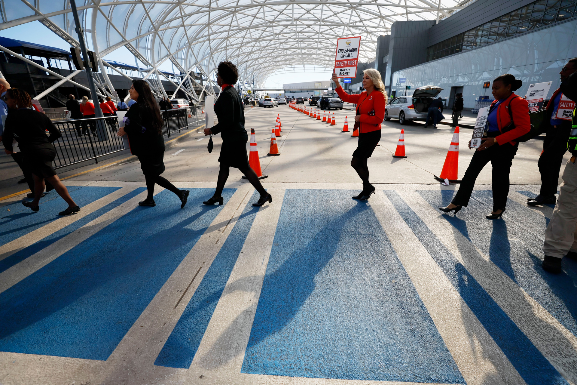 A group of Southwest flight attendants crosses the path to reach the median sidewalk to protest outside the North Terminal at Hartsfield-Jackson Atlanta International Airport on Tuesday, September 27, 2022. The Atlanta group joined Southwest Airlines flight attendants at 11 bases across the country to demand change for their workgroup.