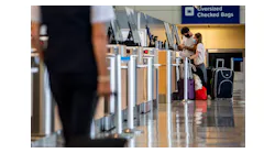 Passengers check their luggage in Terminal D at DFW International Airport in 2020.