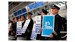 American Airlines first officer Ken Abernathy, right, joins pilots representing the Allied Pilots Association in rallying for a new contract In January 2022 in Dallas.