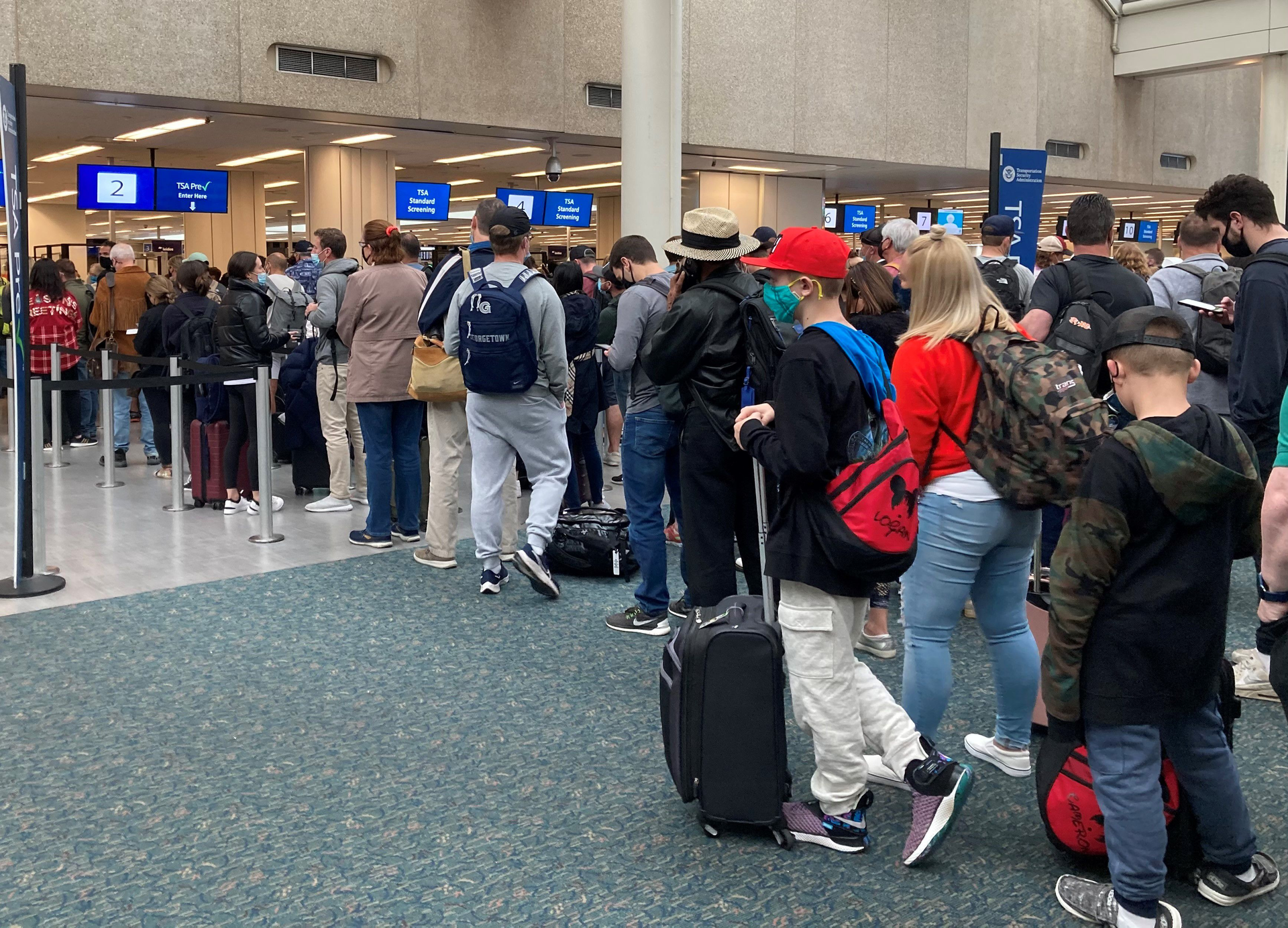Travelers wait in security check lines at Orlando International Airport.