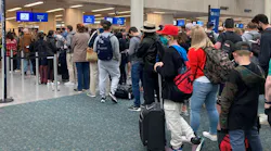 Travelers wait in security check lines at Orlando International Airport.