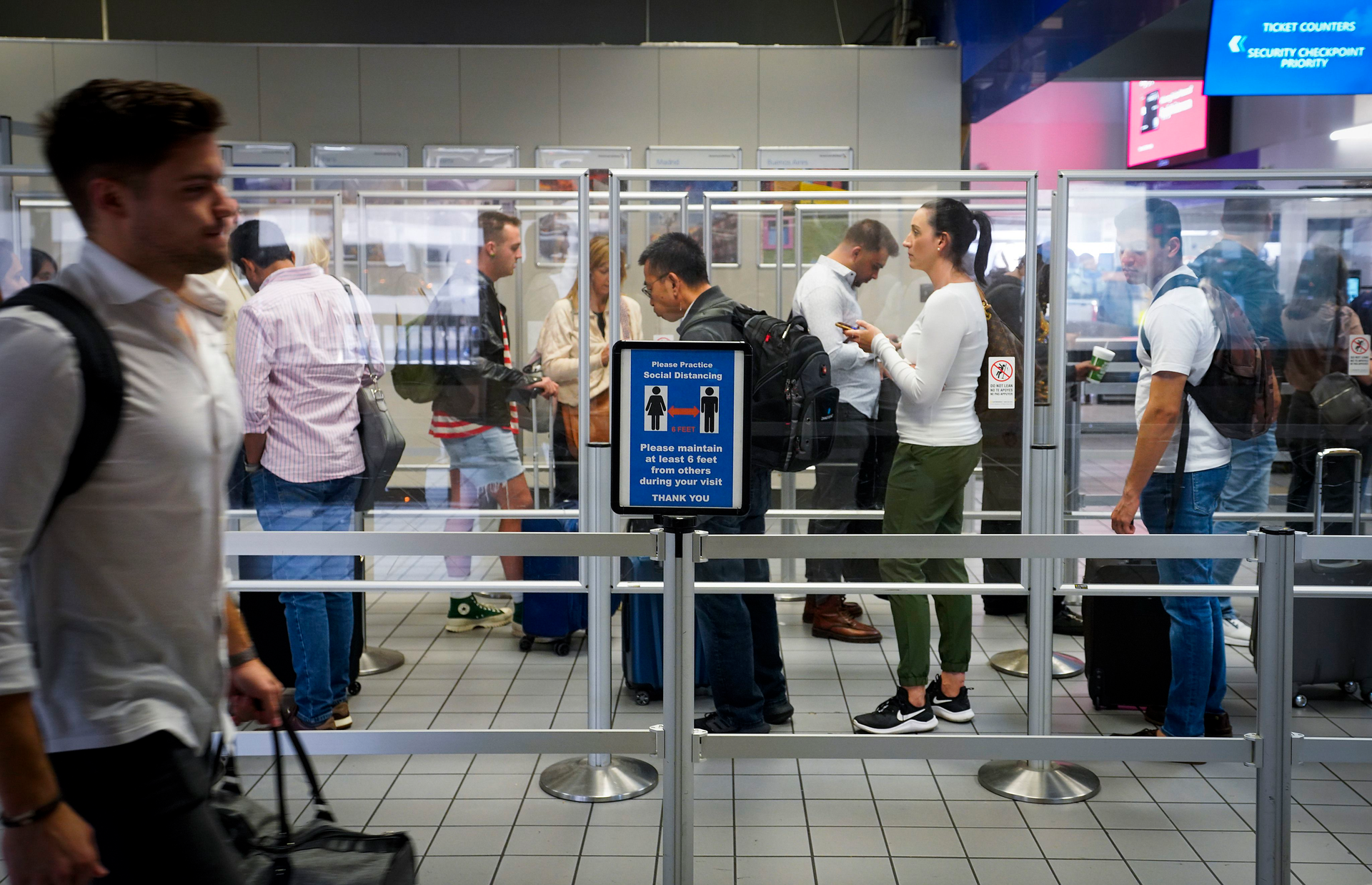 Departing passengers wait in line at a security checkpoint at Terminal C at DFW Airport on Oct. 22.
