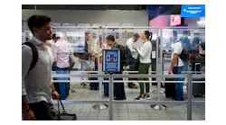 Departing passengers wait in line at a security checkpoint at Terminal C at DFW Airport on Oct. 22.