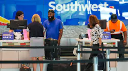 Southwest Airlines ticketing and ramp agents work at a check-in desk at Dallas Love Field in July.