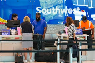 Southwest Airlines ticketing and ramp agents work at a check-in desk at Dallas Love Field in July.