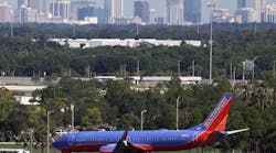 A Southwest airlines jet taxies to the terminal, past the Orlando skyline, on Thursday, September 1, 2022.