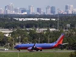 A Southwest airlines jet taxies to the terminal, past the Orlando skyline, on Thursday, September 1, 2022.